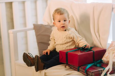 Little boy sitting on bench outside in Christmas time. Happy childの写真素材