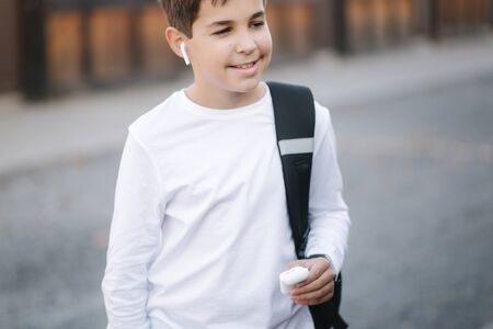 Teenage boy use wireless headphones for listening musicの写真素材