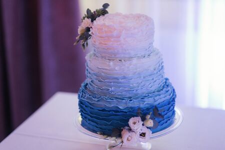 Beautiful wedding cake decorated with flowers. Blue and white color of cakeの写真素材