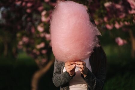 Girl hide behind big pink cotton candyの写真素材