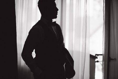 Silhouette of groom in the morning at hotelの写真素材