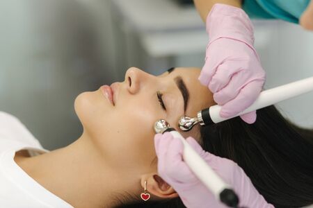 Close up of female face with soft skin. Woman at cosmetology clinic taking a beauty procedure for skin clining. Electrophoresisの写真素材