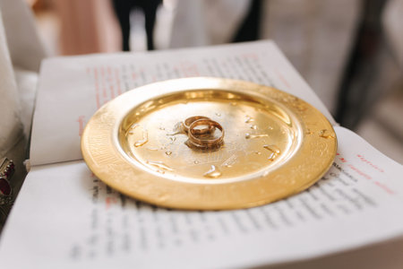 Wedding rings on golden plate in church