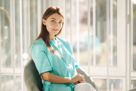 Female cosmetologist in green robe. Beautiful doctor in beauty salonの写真素材