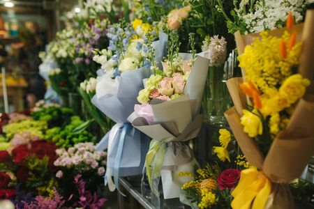 Different varieties fresh spring flowers in refrigerator room for flowers. Beautiful flowers in cold room with air conditioning. Bouquets on shelf, florist business in refrigerator for flowers. Tulinp, roses, peonyの写真素材