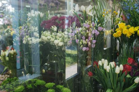 Different varieties fresh spring flowers in refrigerator room for flowers. Beautiful flowers in cold room with air conditioning. Bouquets on shelf, florist business in refrigerator for flowers. Tulinp, roses, peonyの写真素材