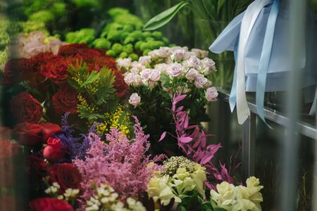 Different varieties fresh spring flowers in refrigerator room for flowers. Beautiful flowers in cold room with air conditioning. Bouquets on shelf, florist business in refrigerator for flowers. Tulinp, roses, peonyの写真素材