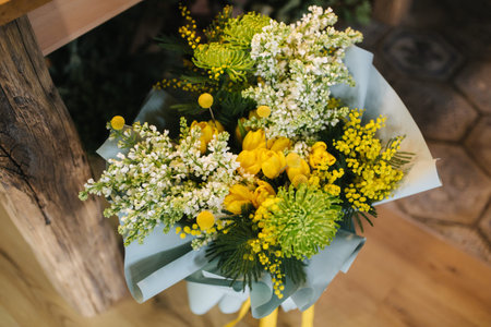 Spring bouquet with yellow tulips and white lilacby the wooden table.の写真素材