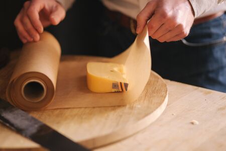 Hand of young man packing slice of cheeseの写真素材