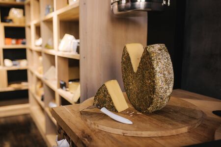 Big piece of lactose-free cheese on wooden boardの写真素材