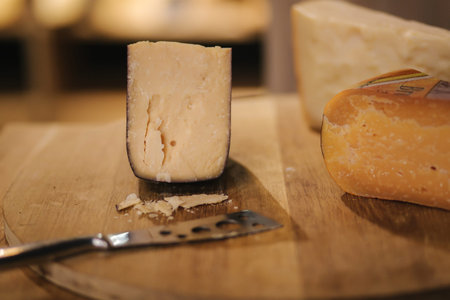 Different types of aged cheese on wooden board.
