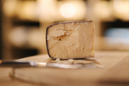 Aged cheese on wooden board. Cheese knife