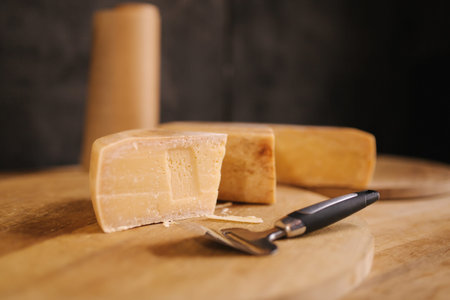 Cheese with knife of wooden board in cheese shop