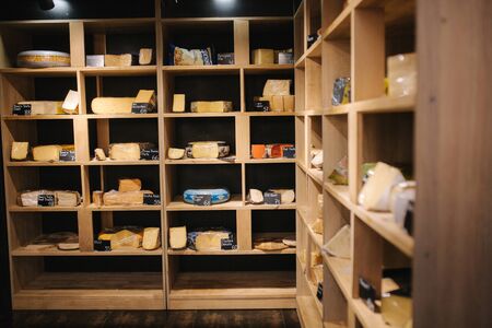 Shelf with cheese in cheese store. Assortment of different cheese.の写真素材