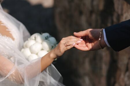 Groom hold bride's han. Close up of hands. Beautiful.の写真素材