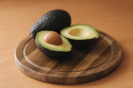 Fresh sliced avocado on wooden board. Vegetarian food concept.の写真素材