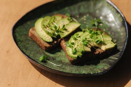Avocado toast on green plate. Vegetarian food concept. Fresh food at home. Sandwich with avocado and...