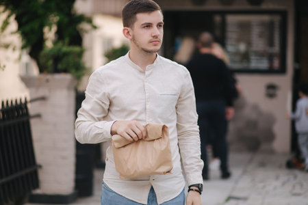 Young man take fresh food from vegan caffe outdoor