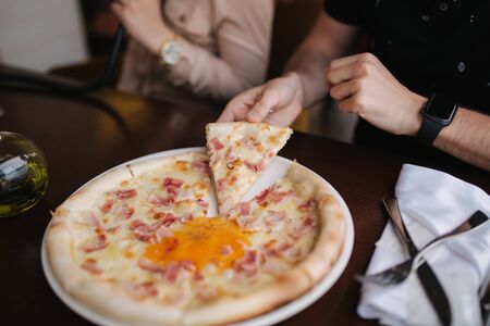 Close up of man take slice of pizza in restaurant.の写真素材