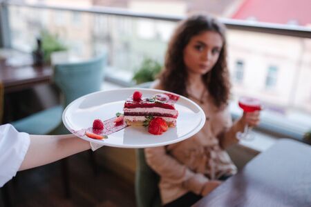Close up of pastry chef bring strawbery cake for special customer. Sweet strawery dessert for womanの写真素材