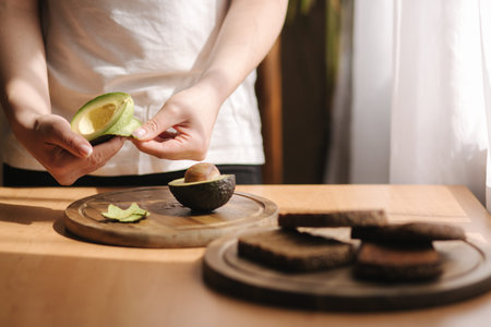 Middle selection of female pill an avocado on wooden board at home. Vegetarian food concept