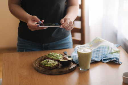 Woman make photo of lunch at home. Female glogger make food photography. Healthy vegan food. Toast...