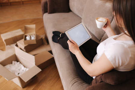Woman shopping online at home use tablet. Woman work on tablet and drink cappuccino. Quarantine...