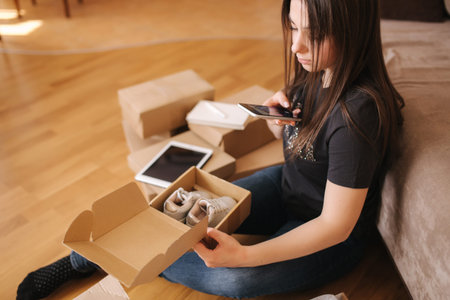 Happy young woman shopping online. Woman use laptop and tablet for searching new goods. Attractive...
