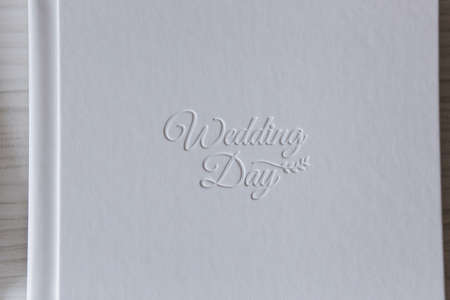 Photobook with different lettering on white wooden tableの写真素材