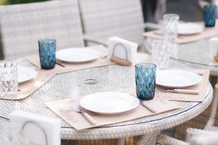 Served table set at suumer terrace. Cutlery in cafe. Green background