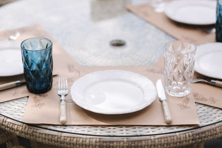 Close up of Served table set at suumer terrace. Cutlery in cafe. Blue glassesの写真素材