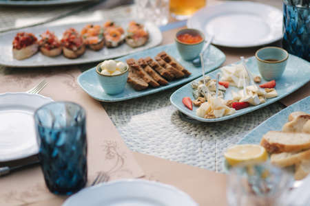 Different kinds of cheeses on served table at summer terrace in cafe. Food concept. Different kind of food on the tableの写真素材