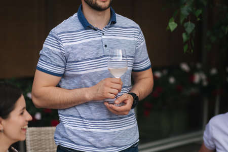 Man hold glass of wine in hand, middle selectionの写真素材