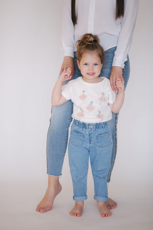 Little girl with mom in studio. White background