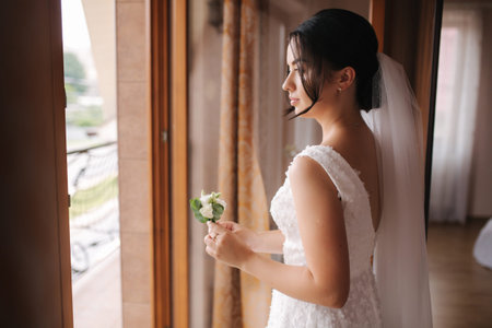 First look of groom and bride at bridess home. Tender bride Stand by the window and wait for groomの写真素材