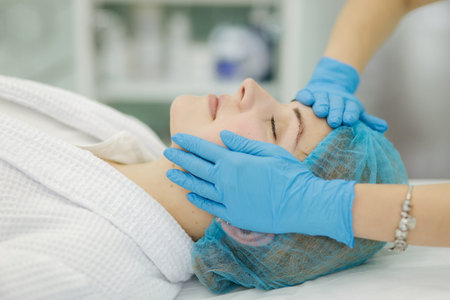 Cosmetoligist make facial massage in beauty salon. Preparing for injection. Cosmetologist in...