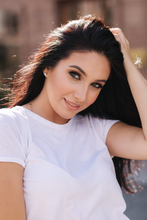 Portrait of beautiful young brunette woman in white t-shirt. Beautiful makeupの写真素材