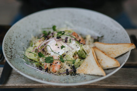 Close up of fresh vegan salad with shrimps outdoor in cafe on terrace