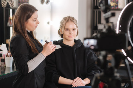 Woman make makeup for attractive blond hair woman in studio. Video of makeup artist applying...