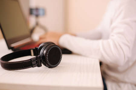 Close up of wireless on-ear heandphones in front of teenage gamer playingの写真素材