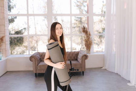 Happy young woman preparing for traiting at home. Attractive female use katemat fot pitalesの写真素材