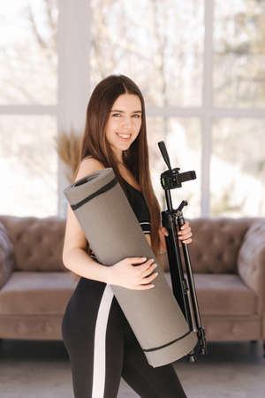 Happy young woman preparing for traiting at home. Attractive female use katemat fot pitalesの写真素材