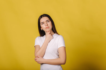 Portrait of pretty woman standing isolated over yellow background. Looking camera. Everything is...