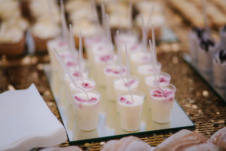 Cake bar on wedding. Differnt type of sweeties on the table. Eclair, cake pops, muffins and mamy others dessertsの写真素材