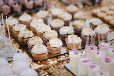 Cake bar on wedding. Differnt type of sweeties on the table. Eclair, cake pops, muffins and mamy others dessertsの写真素材