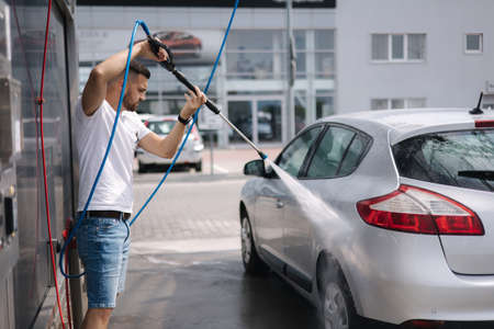 Process of man washing his car in a self-service car wash stationの写真素材