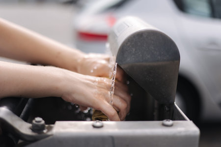 Female wash rug in water. Close-up womans hand in front of car on sel servise car wash