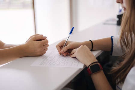 Close up of female and doctors hand on table during writes the recipeの写真素材