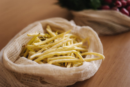 Green beans in canvas grocery bag. Eggs from eco farm. Cotton bags on wooden table. Zero waste...