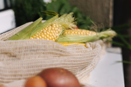 Fresh raw corn in eco canvas grocery bag. Cotton bags with vegetables. Zero waste shopping concept. Plastic free itemsの写真素材